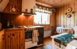 cocina con fogones, fregadero y mesa en 1 Bedroom Awesome Home In motfors en Åmotsfors