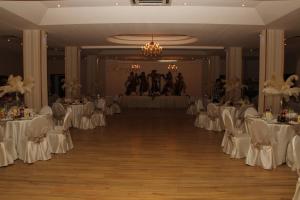 a banquet hall with white tables and white chairs at Hotel Royal in Urziceni