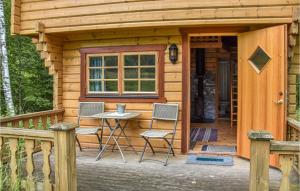 Cabaña con 2 sillas y mesa en el porche en Amazing Home In rjng With Kitchen en Årjäng