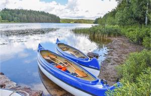 dos barcos sentados en la orilla de un lago en Amazing Home In rjng With Kitchen en Årjäng