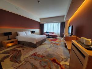 花蓮市にあるParkview Hotels & Resortsのベッド1台、薄型テレビが備わるホテルルームです。