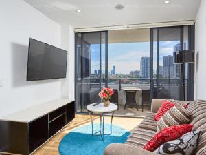 un salon avec un canapé et une télévision à écran plat dans l'établissement Ruby Gold Coast By Serain, à Gold Coast