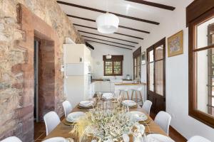 a dining room with a table and a brick wall at Luxury Villa El Turo in Castellví de Rosanés