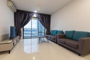 uma sala de estar com um sofá e uma televisão em Teega Suites @ UHA em Nusajaya