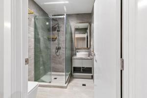 a bathroom with a shower and a sink at Kolmar Inn in Auckland