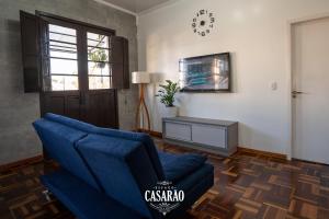 Espaço Casarão - Serra Gaúcha في Cotiporã: غرفة معيشة مع أريكة زرقاء ونافذة