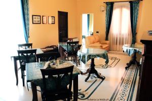 a living room with tables and chairs and a couch at Il Casale dei Conti in Barcellona-Pozzo di Gotto