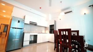 a kitchen with a table and chairs and a refrigerator at The Beach Front Apartment - Colombo, Uswetakeiyawa, Colombo in Wattala