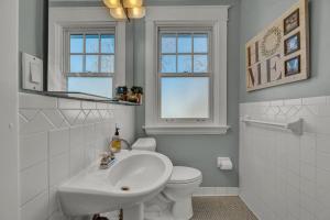 a white bathroom with a sink and a toilet at Oakley Square 3BR Charmer - Total Walkability home in Cincinnati +34 photos