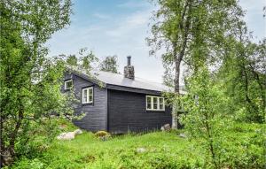 Ein schwarzes Haus mitten auf einem Feld in der Unterkunft Lovely Home In Norheimsund With Wifi in Norheimsund