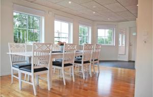 une salle à manger avec une table et des chaises blanches dans l'établissement 2 Bedroom Cozy Apartment In Habo, à Mullsjö