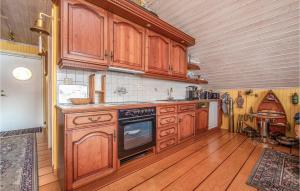 eine Küche mit Holzschränken und Holzböden in der Unterkunft Beautiful Home In Hundeidvik in Hundeidvik