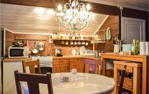 een keuken met een tafel en een kroonluchter bij 3 Bedroom Beautiful Home In Eikefjord in Eikefjord