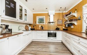 a large kitchen with white cabinets and a counter top at Gorgeous Home In Vestnes With Wifi in Vestnes