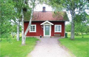 una casa roja con techo rojo y un camino a ella en Amazing Home In Lundsbrunn With 3 Bedrooms, en Lundsbrunn