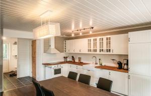 a kitchen with white cabinets and a table and chairs at Gorgeous Home In Søre Osen With Wifi in Tørberget