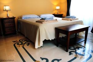 a bedroom with a bed and a table with towels on it at Il Casale dei Conti in Barcellona-Pozzo di Gotto