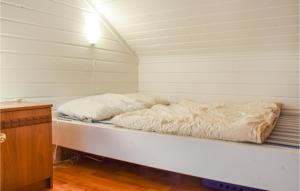 a bed in a room with white sheets on it at Awesome Home In Nord-Torpa With Kitchen in Nord Torpa +5 photos