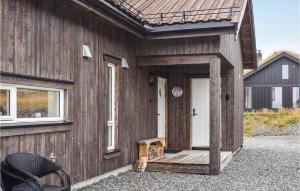 a cat sitting on the porch of a wooden house at Awesome Home In yer With House A Mountain View in Øyer