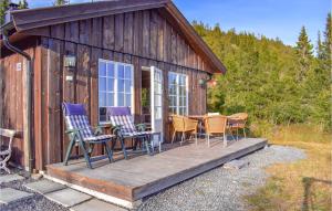 a cabin with chairs and a table on a deck at Nice Home In Etnedal With 3 Bedrooms in Etnedal