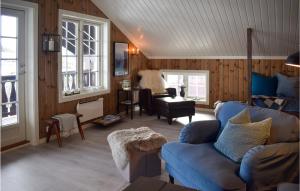uma sala de estar com paredes de madeira e um sofá azul em 4 Bedroom Cozy Home In Eggedal em Eggedal