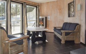 uma sala de estar com cadeiras, uma mesa e uma lareira em Staven Appartments em Hemsedal