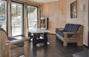 a living room with chairs and a table and a fireplace at Staven Appartments in Hemsedal