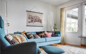 a living room with a blue couch with pillows at Nice Home In Höganäs With Wifi in Höganäs