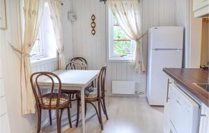 a kitchen with a table and chairs and a refrigerator at Stunning Home In sgrdstrand With Wifi in Åsgårdstrand