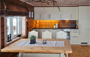 a kitchen with a wooden table and white cabinets at Awesome Home In seral With 3 Bedrooms And Sauna in Åseral