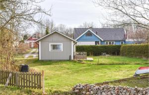 une maison avec une clôture dans une cour dans l'établissement Pet Friendly Home In Hassl With Kitchen, à Hasslö