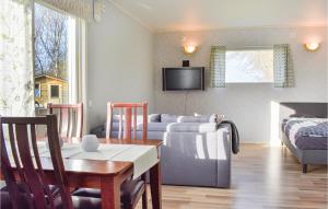 a living room with a couch and a dining room at Pet Friendly Home In Hassl With Kitchen in Hasslö
