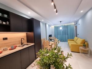 een keuken en een woonkamer met een gele bank bij Holiday apartment near the sea in Durrës