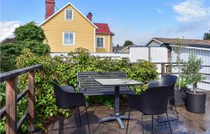 a table and chairs in front of a fence at Cozy Home In Karlskrona With Kitchen in Karlskrona