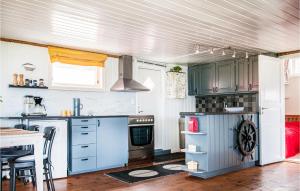 a kitchen with blue cabinets and a stove top oven at Nice Home In Malvik With Kitchen in Malvik