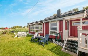 una caravana roja en la hierba con una mesa y sillas en Nice Home In Malvik With Kitchen, en Malvik
