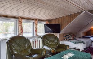 ein Schlafzimmer mit 2 Ledersesseln, einem Bett und einem TV in der Unterkunft Awesome Apartment In Risr With Lake View in Risør