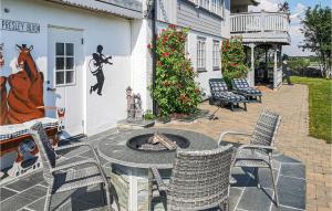 un patio con sillas y una hoguera frente a una casa en Lovely Apartment In Vallersund With Kitchen, en Drilen
