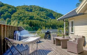 un patio con sedie e griglia e montagne sullo sfondo di 3 Bedroom Lovely Home In Farsund a Farsund