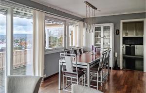 comedor con mesa, sillas y ventanas en Nice Home In Kristiansand With 4 Bedrooms And Wifi, en Kristiansand