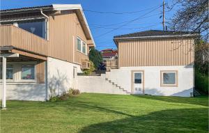 una casa con un patio de hierba delante de ella en Nice Home In Kristiansand With 4 Bedrooms And Wifi, en Kristiansand