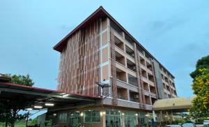ein hohes Gebäude mit einem Dach darüber in der Unterkunft A.K. Terrace Hotel in Sara Buri