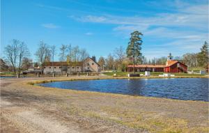 a pond in front of a red barn and a red building at Nice Home In Kosta With Kitchen in Kosta