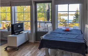 comedor con mesa, TV y ventanas en 3 Bedroom Stunning Home In Lekeryd, en Lekeryd