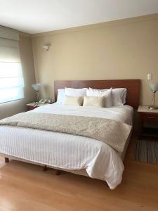 a bedroom with a large bed with white sheets and pillows at Cozy Stylish room in Polanco in Mexico City