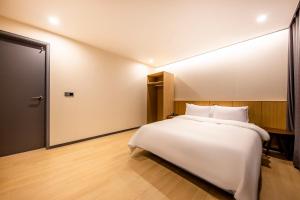 a bedroom with a white bed and a large mirror at Benikea hotel in Cheonan