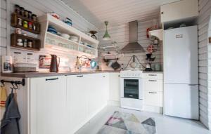 a kitchen with white cabinets and a refrigerator at Nice Home In Bjerkvik With 3 Bedrooms, Sauna And Wifi in Bjerkvik