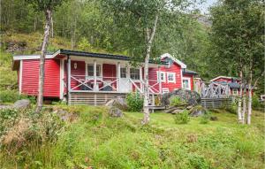 a red cabin in the middle of a forest at Nice Home In Bjerkvik With 3 Bedrooms, Sauna And Wifi in Bjerkvik