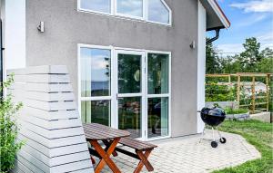 Stunning Home In Oskarshamn With Wifi في أوسكارسهامن: وجود شواية وطاولة نزهة أمام المنزل