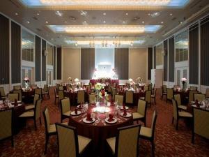 un salón de banquetes con mesas y sillas en una habitación en Sendai Hills Hotel en Sendai